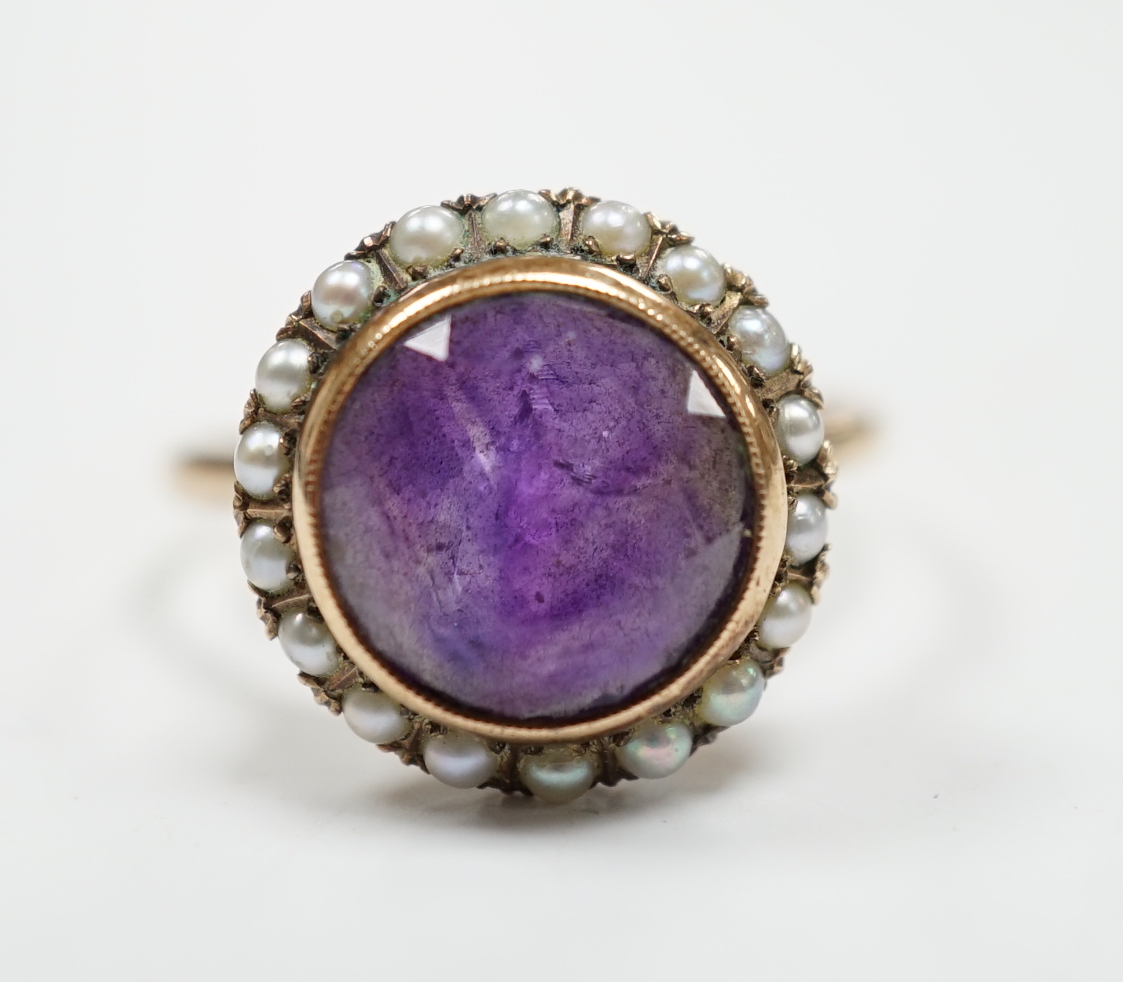 A mid 20th century 14k yellow metal, amethyst and seed pearl set circular cluster ring, size U/V, gross weight 4.3 grams.